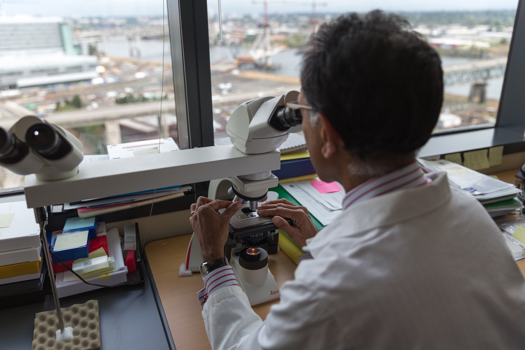 Researcher G Thomas looking into a microscrope